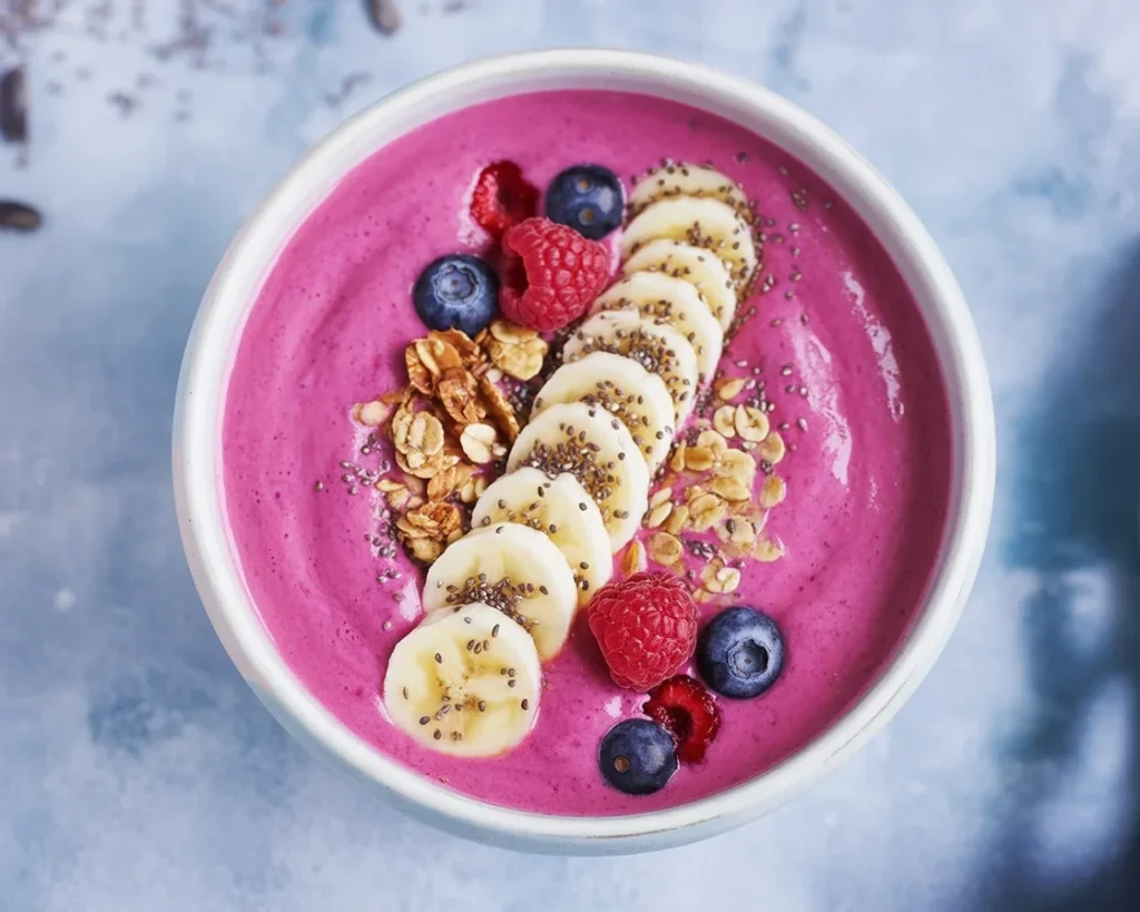 Smoothie bowl aux fruits rouges, banane et yaourt décoré avec des fruits frais